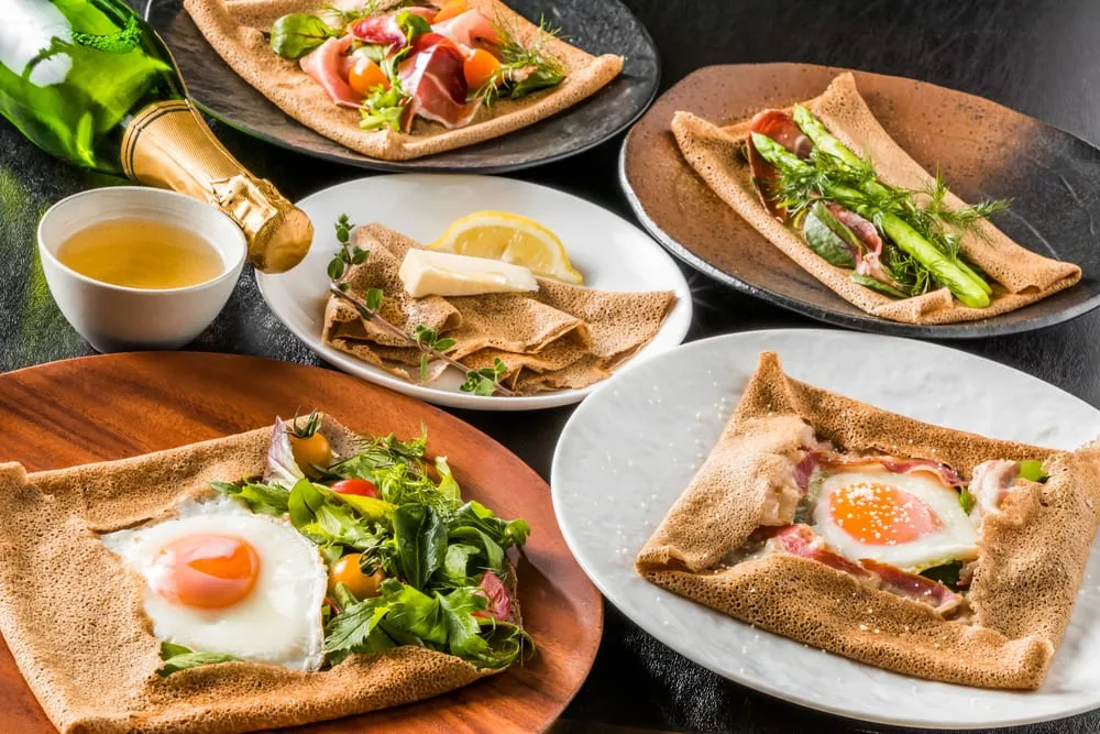 Assortiment de galettes bretonnes garnies oeuf jambon fromage et légumes