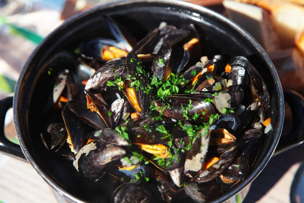 Cocotte de moules marinières persillées servies face à la mer